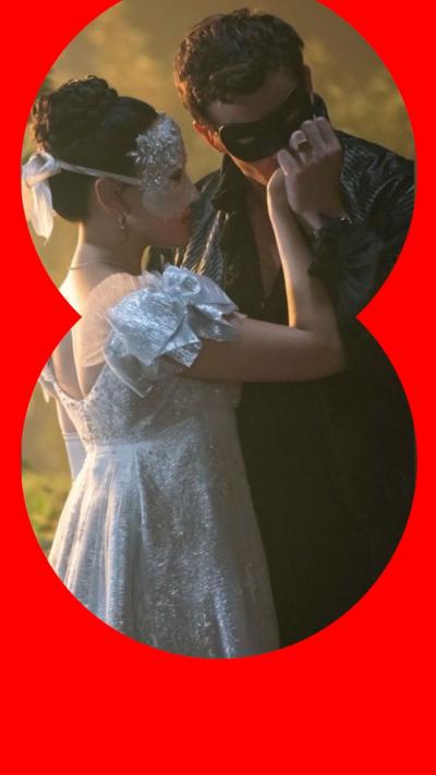 Benedict Bridgerton, in black clothes, kissing the hand of Sophie Baek, in a white dress. Both are masked.