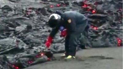 Scientist collecting lava sample