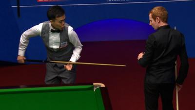 Marco Fu pokes Anthony McGill with his snooker cue