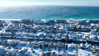 Beach holiday peninsula covered in snow, shown on still from drone video