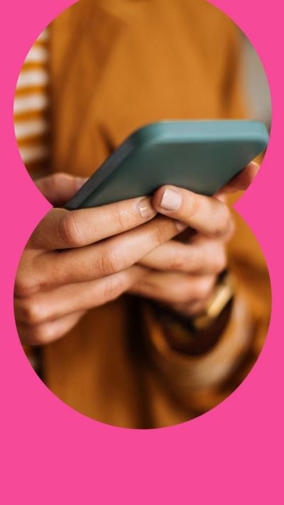 Torso of someone in brown shirt holding their mobile phone