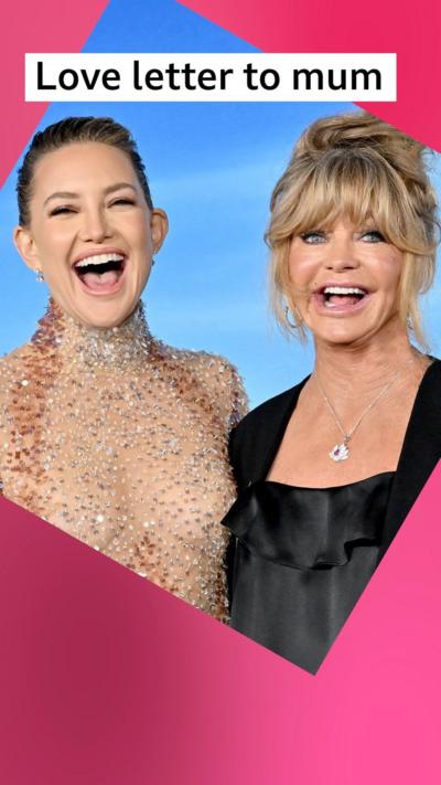 Kate Hudson and Goldie Hawn stand together with big smiles - Kate wears a sequin top, Goldie wears a black jacket