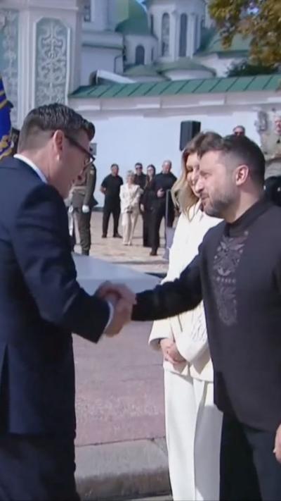 Burnham shakes hands with Zelensky during the ceremony with wife Olena Zelenska beside them