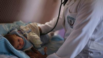 A doctor treating a child in Syria