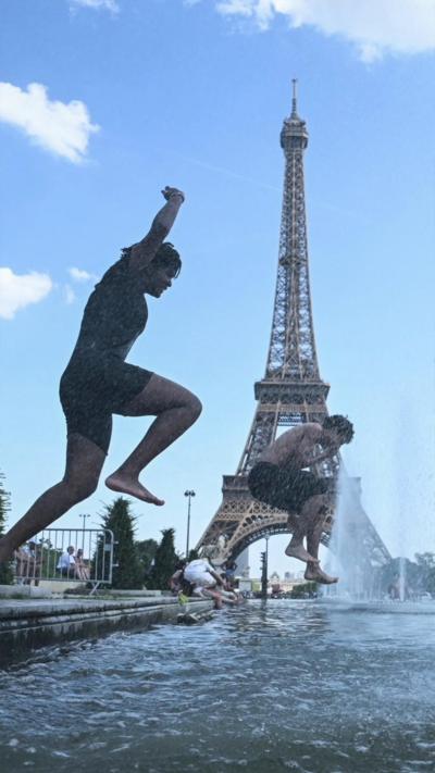 People jump in fountain near the Eiffel Tower