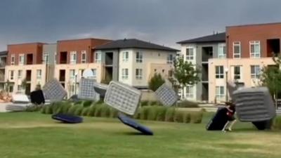 Dozens of air mattresses are swept away by the wind before an outdoor movie night in Colorado.