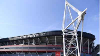 The Principality Stadium with an abseiling cleaner
