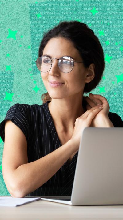 A woman sitting in front of her laptop, smiling