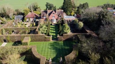 The aerial images show an immaculate and expansive private garden that is being left to a charity.