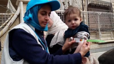 A UNICEF employee measuring the arm of a malnourished child in the besieged Syrian town of Madaya