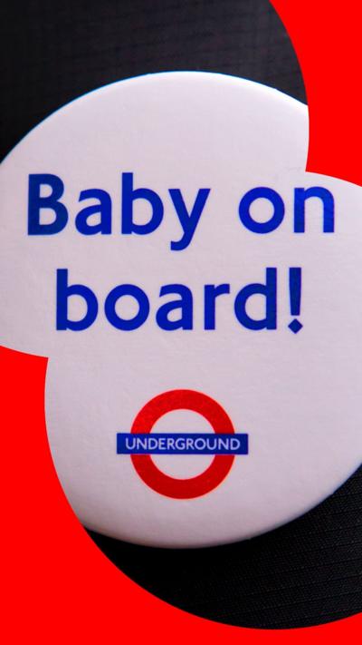 A white button badge with the words "Baby on board!" in blue, written above the London Underground logo.