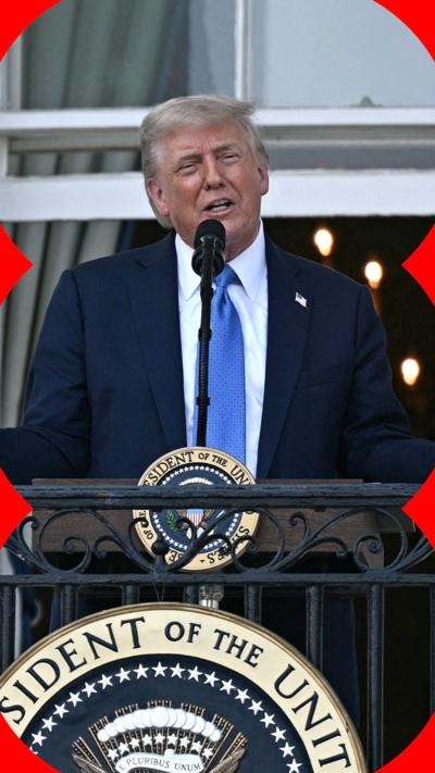 Trump standing at a podium behind a microphone 