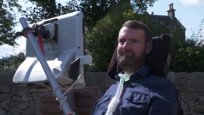 Euan MacDonald outside accessible accommodation