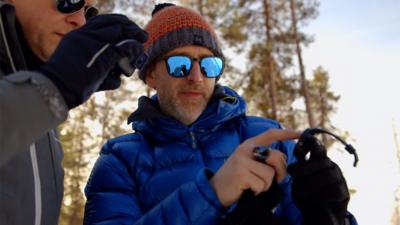 Two men looking at watch in the Arctic Circle