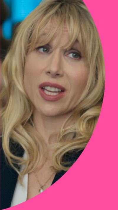 A woman with shoulder-length blonde hair looks at someone off-camera