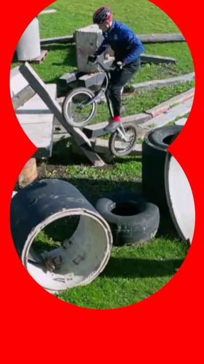 Charlie rides his bike on an obstacle course made up of multiple objects on grass