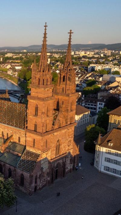 A drone view shows the Basel Muenster Cathedral above the Rhine river