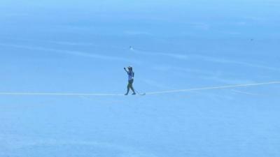 Jaan Roose walking a slackline high above water 