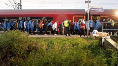 Migrants board a train at the Austrian village of Nickelsdorf after arriving from Hungary