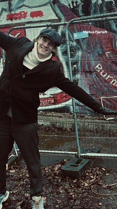 Markus is smiling with his arms and hands stretched.