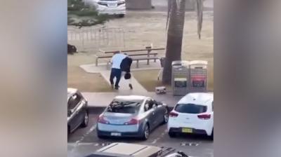 A man in a white top, with his arm around an alleged gunman.