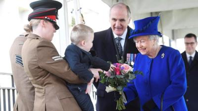 The Queen being given a bouquet by two-year-old Alfie Lunn