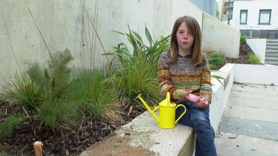 Girl sitting by planter