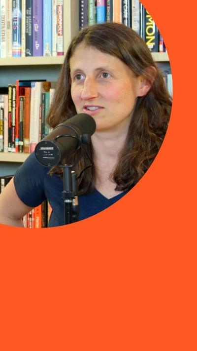 Woman speaking into a podcast microphone in front of a bookshelf