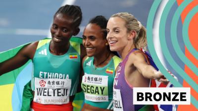 Diribe Welteji, Guraf Tsegay and Georgia Hunter Bell pose for pictures with their flags