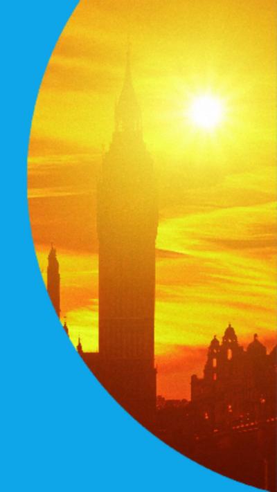 Silhouette of Big Ben clock tower in London with blazing sun in the background.