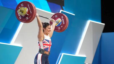 Bella can be see holding lifting weights above her head as she competed at European Weightlifting Championships