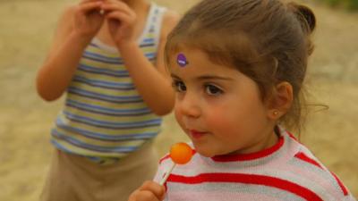 Young migrant girl with lollypop