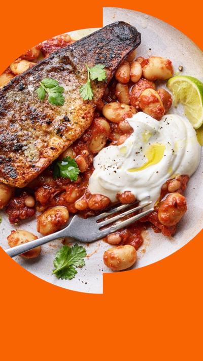 Store cupboard spiced bean stew on a plate with a sea bass fillet