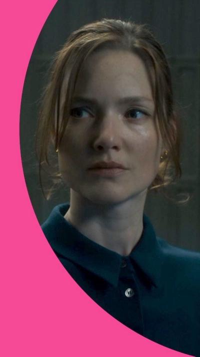 Character Rachel wears a blue shirt and looks to her right