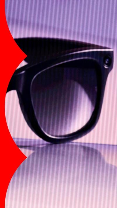 A close up on one lens and camera on a pair of black-rimmed smart glasses.