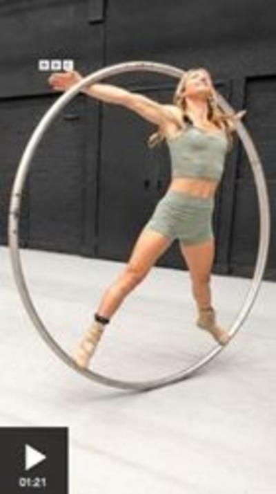 A woman stands in a metal circle.
