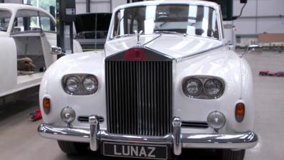 A white Rolls Royce with an Lunaz number plate is parked in a workshop