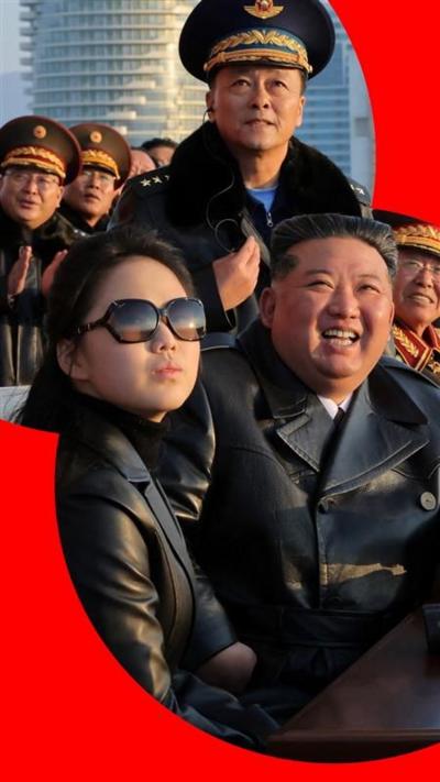 Kim Jong Un with daughter Kim Ju Ae dressed in black leather outfits with military men behind them