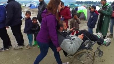 A Syrian refugee being pushed in a wheel chair in Idomeni, Greece.