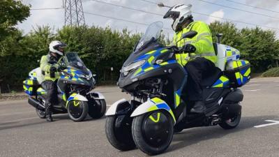 Police officers ride petrol-electric hybrid motorcycles