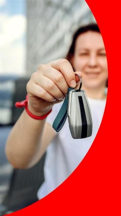 A woman in a white t shirt with a bob holds car keys to the camera, with a car behind her.