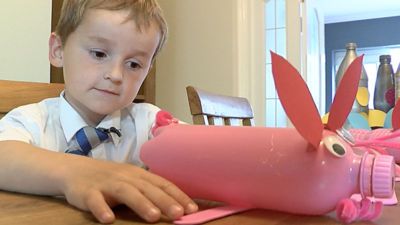 Noah with one of his piggy banks