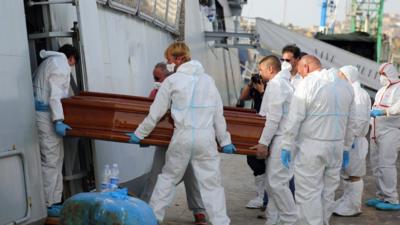 A coffin is carried out of the Italian Navy ship Bettica, at the Sicilian Porto Empedocle harbor, Italy.