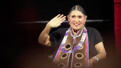 Sacheen Littlefeather waving