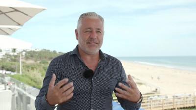 Man in shirt standing in front of a beach