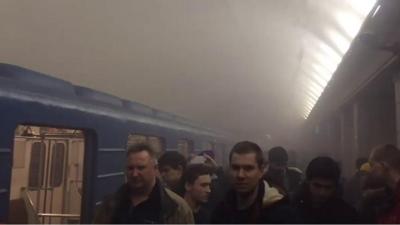 Passengers surrounded by smoke on a St Petersburg metro platform