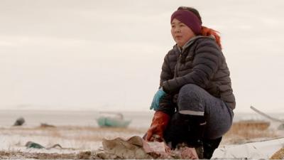 A local woman with a seal carcass in northern Alaska