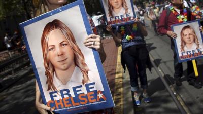 People hold signs calling for the release of imprisoned wikileaks whistleblower Chelsea Manning