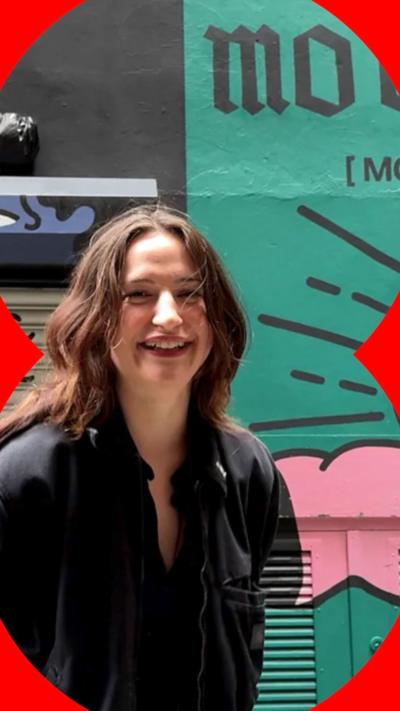 Katie Forbes smiles in front of her Mo Chridhe mural