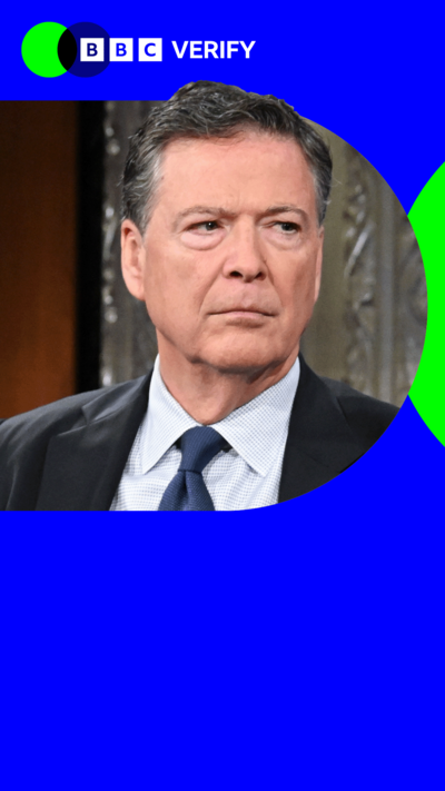 Ex-FBI Director James Comey appearing at a conference. He is wearing a dark suit and tie and is staring off camera. 